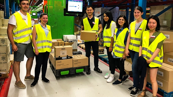 students wearing safety wests, standing in the middle of the dm distribution center