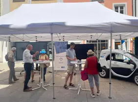 Picture of the research vehicle ANTON (Renault Twizy), and citizens interacting with Prof. Vaculin.
