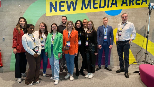 Group picture with eleven people in front of a colorful wall.