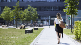 A student is walking across the campus